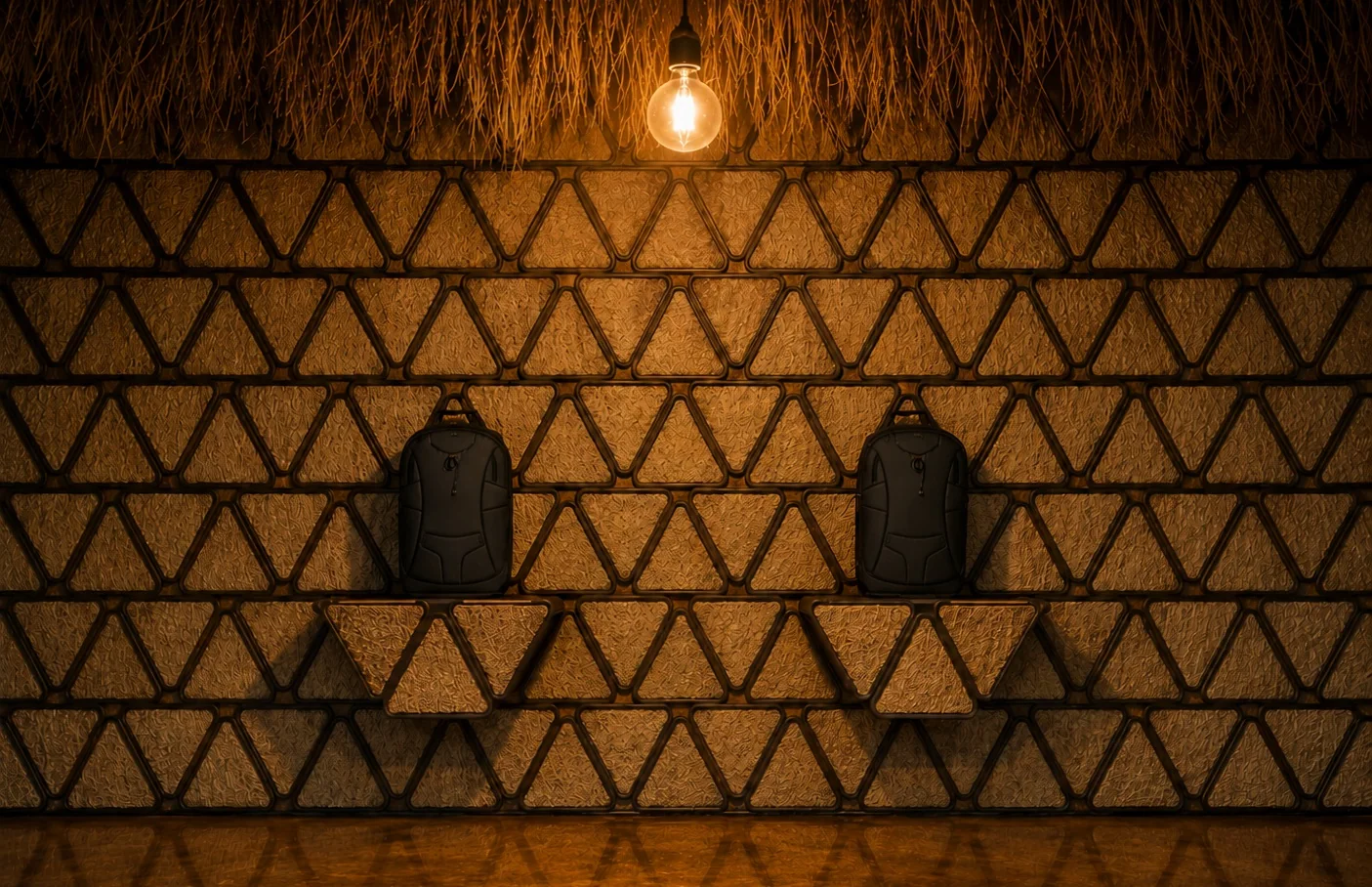 Close-up of Cacique triangular wall panels and warm exposed bulb